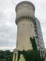 een groot wit oud steen steen ronde water toren overwoekerd met gebladerte en groen foto