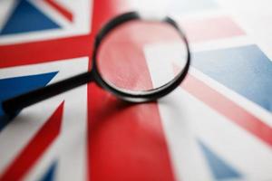 uk vlag op zoek door een vergroten glas. totaal toezicht van de land van Engeland. de concept van verborgen gevaren en controle over- de land foto