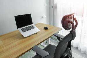 ergonomisch stoel en verstelbaar tafel met laptop computer in modern werkplek. mooi zo houding naar vermijden kantoor syndroom, terug pijn, schouder pijn, fibromyalgie en nek pijn foto