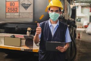 veiligheid officieren inspecteren gevaarlijk chemisch vrachtwagens in industrieel planten. foto