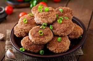 sappig heerlijk vlees schnitzels Aan een houten tafel in een rustiek stijl. foto