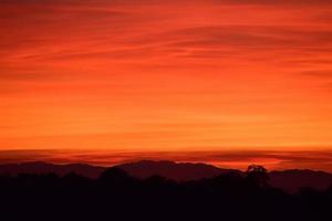 silhouet van berg onder oranje hemel foto