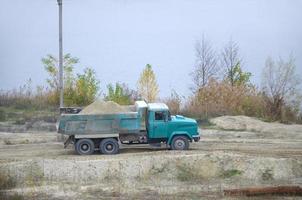 dump vrachtauto transporten zand en andere mineralen in de mijnbouw groeve. zwaar industrie foto