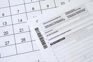 Duitse belasting het formulier leugens Aan kantoor kalender. concept van belasting betalen in Duitsland foto