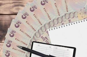 5 Turks lire rekeningen ventilator en kladblok met contact boek en zwart pen. concept van financieel planning en bedrijf strategie foto