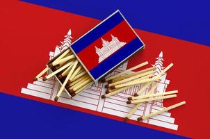 Cambodja vlag is getoond Aan een Open luciferdoosje, van welke meerdere wedstrijden vallen en leugens Aan een groot vlag foto