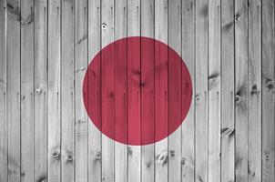 Japan vlag afgebeeld in helder verf kleuren Aan oud houten muur. getextureerde banier Aan ruw achtergrond foto