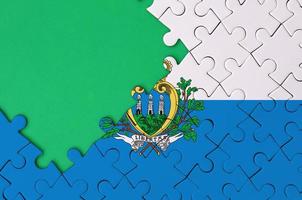 san marino vlag is afgebeeld Aan een voltooid decoupeerzaag puzzel met vrij groen kopiëren ruimte Aan de links kant foto