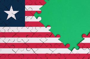 Liberia vlag is afgebeeld Aan een voltooid decoupeerzaag puzzel met vrij groen kopiëren ruimte Aan de Rechtsaf kant foto