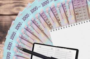 1000 oekraïens grivna's rekeningen ventilator en kladblok met contact boek en zwart pen. concept van financieel planning en bedrijf strategie foto