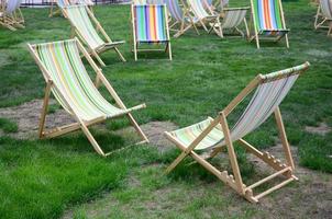 sjees lounges Aan een gazon. tuin ligbedden Aan groen gras foto