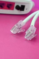 internet router en internet kabel pluggen liggen Aan een helder roze achtergrond. items verplicht voor internet foto