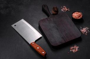 houten snijdend bord met keuken huishoudelijke apparaten Aan een zwart beton achtergrond foto