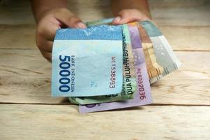hand- van jong kind Holding Indonesisch geld. roepia, idr geld. foto