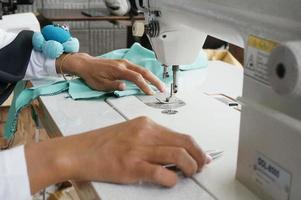 naaien een groen jurk Aan een naaien machine, met selectief focus foto
