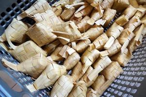 ketupat is Indonesië traditioneel voedsel. ketupat is rijst- taart gekookt in een ruitvormig pakket van gevlochten jong kokosnoot bladeren. foto