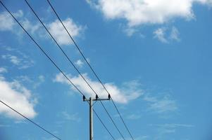 elektrisch pool macht lijnen uitgaand elektrisch draden tegen Aan wolk blauw lucht. foto