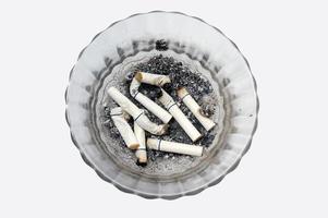 sigaret peuken in een glas asbakje foto