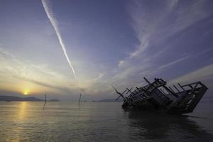 zinkend boot, visie Bij zonsopkomst foto