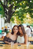 detailopname portret van twee vrouw Bij zomer straat cafe foto