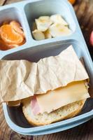 ham en kaas belegd broodje in school- lunchbox, top visie foto