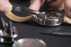 close-up van horlogemaker die een batterij vervangt foto