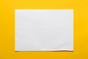 kader van een vel van wit papier Aan een geel achtergrond. kopiëren ruimte. top visie. foto