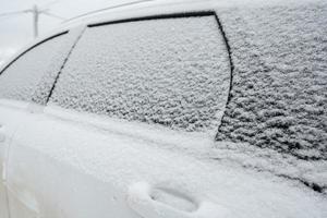 met sneeuw bedekt deuren en ramen van een auto, buitenshuis, Aan een winter dag. foto