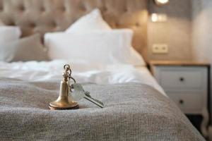 sleutel naar de hotel kamer leugens Aan de bed foto