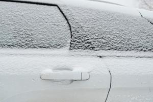 met sneeuw bedekt deuren en ramen van een auto, buitenshuis, Aan een winter dag. foto