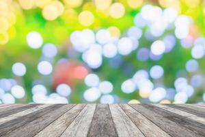 leeg hout tafel top met vervagen Kerstmis boom met bokeh licht achtergrond foto