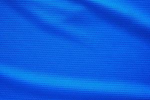 blauw Amerikaans voetbal Jersey kleding kleding stof structuur sport- slijtage achtergrond, dichtbij omhoog top visie foto