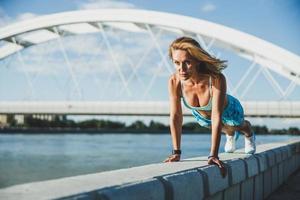 fit vrouw beoefenen Opdrukken gedurende buitenshuis training foto