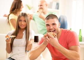 jong mannen aan het eten pizza foto