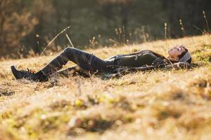 vrouw aan het liegen naar beneden Aan de weide en genieten van zon foto