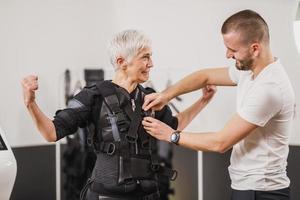 geschiktheid instructeur zetten een ems pak naar een vrouw foto