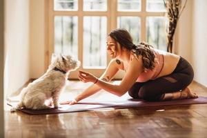 vrouw aan het doen yoga met haar hond foto