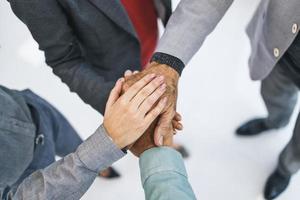 hoog hoek schieten van een groep onherkenbaar bedrijf mensen toetreden hun handen samen in een kruipen foto