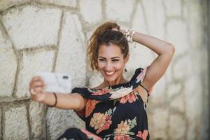 vrouw poseren voor selfie gedurende genieten zomer dag in een middellandse Zee stad foto