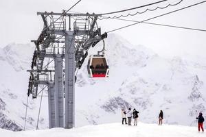 elbrus nationaal park, Rusland - oktober 13, 2022. berg besneeuwd landschap met oprahs, alpine kabel auto hutten en toeristen. foto