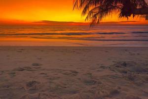 mooi zonsondergang over- de zee met palmen boom Aan tropisch strand de kleurrijk van de lucht bovenstaand de zee voor reizen en vakantie foto