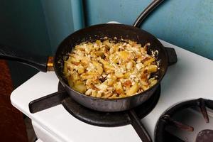 gebakken aardappelen met ei in een frituren pan, voedsel bachelor opleiding, gekookt door een mannelijk, heet en vers foto