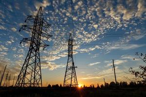 hoog Spanning macht lijn ondersteunt Bij zonsondergang foto