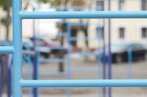 blauw metaal pijpen en dwarsbalken tegen een straat sport- veld- voor opleiding in atletiek. buitenshuis atletisch Sportschool apparatuur. macro foto met selectief focus en extreem wazig achtergrond