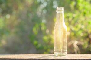 een glazen fles schijnt op een houten vloer foto