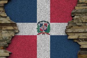 dominicaans republiek vlag afgebeeld in verf kleuren Aan oud steen muur detailopname. getextureerde banier Aan rots muur achtergrond foto