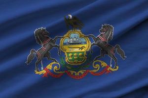 Pennsylvania ons staat vlag met groot vouwen golvend dichtbij omhoog onder de studio licht binnenshuis. de officieel symbolen en kleuren in banier foto