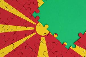 Macedonië vlag is afgebeeld Aan een voltooid decoupeerzaag puzzel met vrij groen kopiëren ruimte Aan de Rechtsaf kant foto
