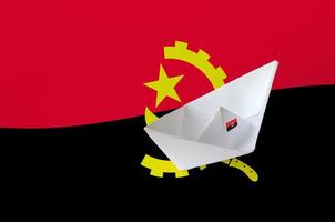 Angola vlag afgebeeld Aan papier origami schip detailopname. handgemaakt kunsten concept foto