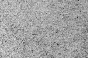 een oud vel van multiplex met fragmenten van ingedrukt zaagsel grijs. foto